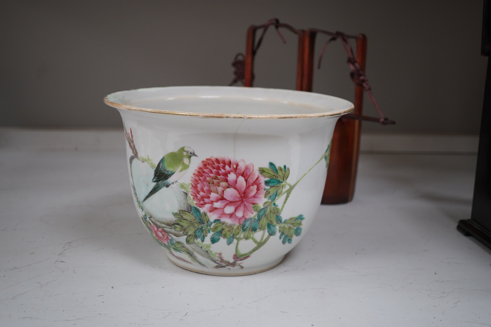 A Chinese famille rose jardiniere and bamboo oak rail, famille rose jardiniere 27cm diameter. Condition - jardiniere cracked from rim and restored, bamboo side cracked